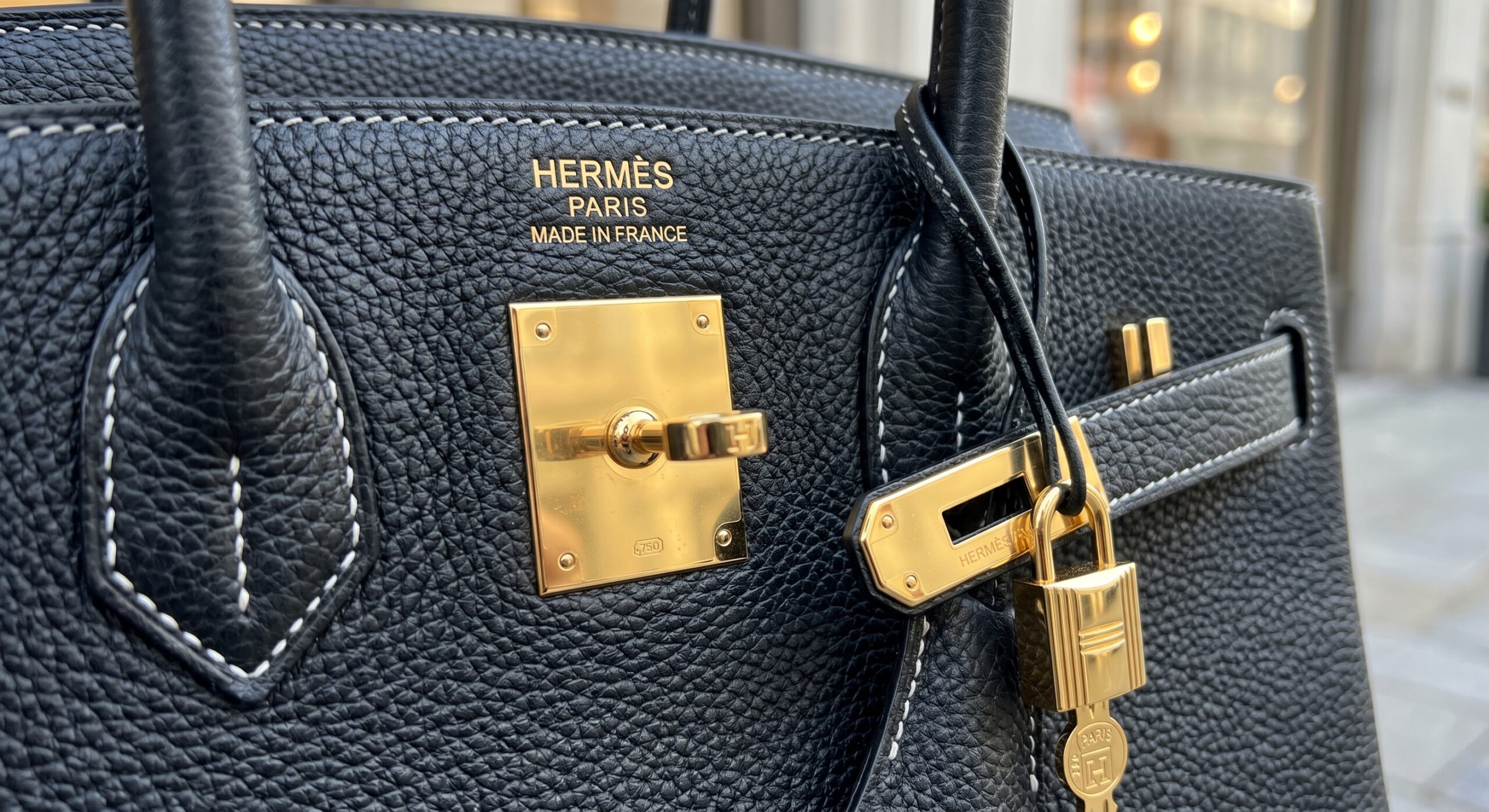 Close-up of Hermès Noir Togo leather detailing the Gold Hardware (GHW) contrast
